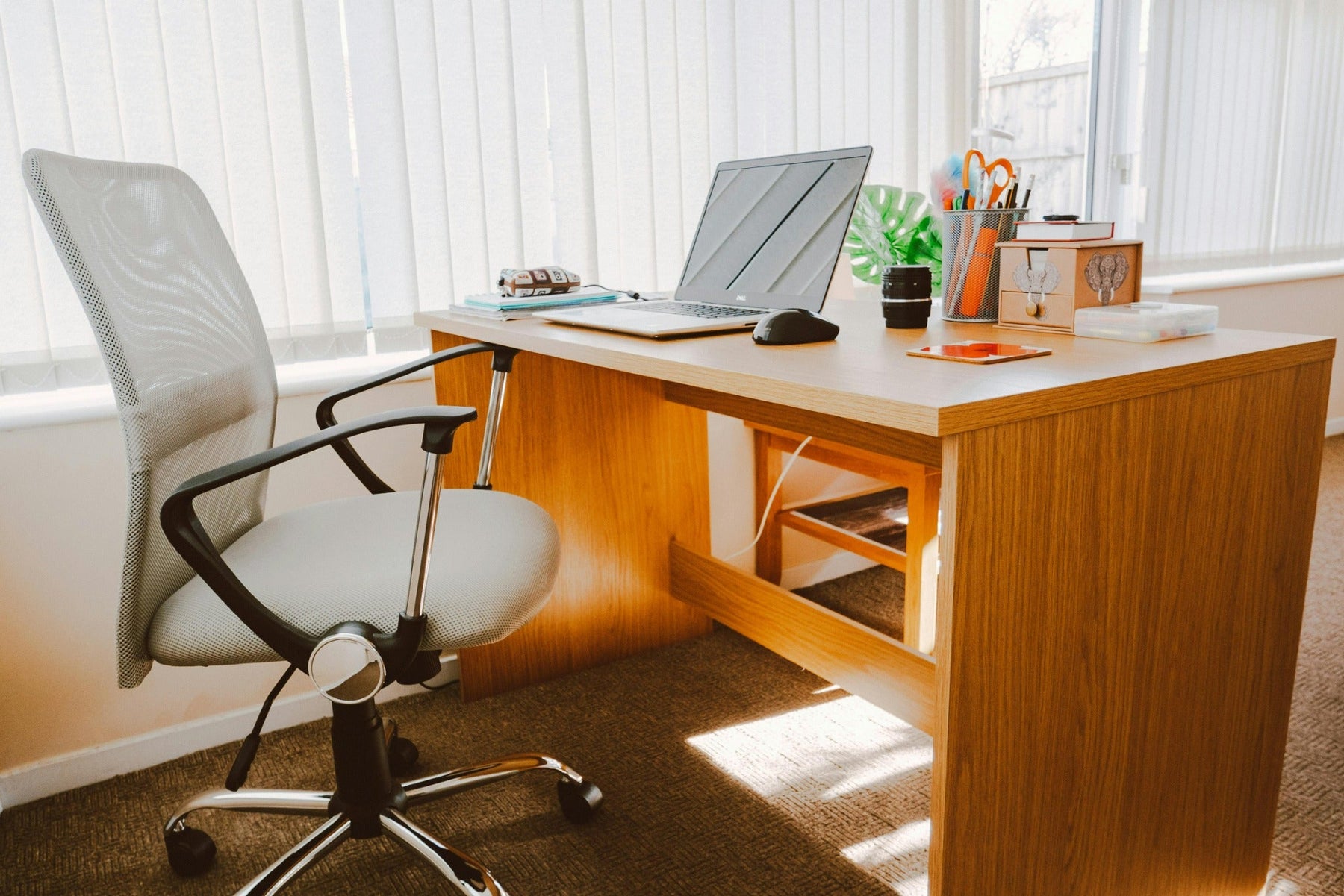 Bright home office desk with laptop and chair