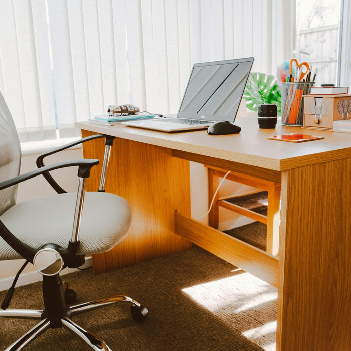 Bright home office desk with laptop and chair