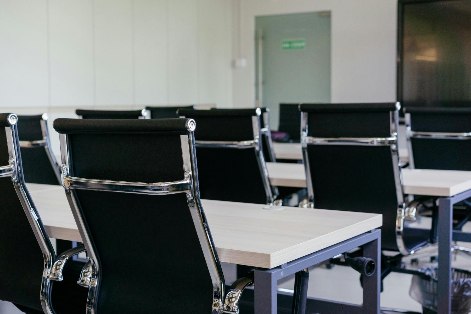 Conference room with black chairs and tables arranged for a meeting