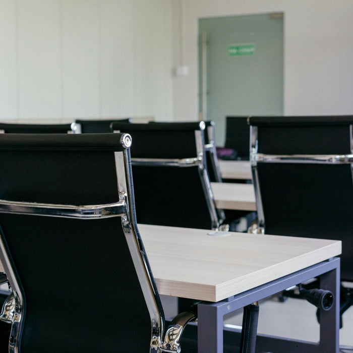 Conference room with black chairs and tables arranged for a meeting