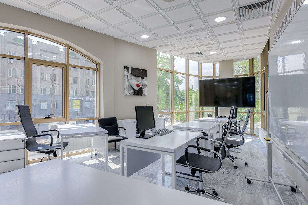 Bright modern office with desks, chairs and presentation screens
