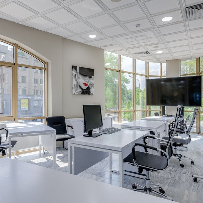 Bright modern office with desks, chairs and presentation screens