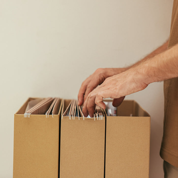 Man organizing hanging file folders in cardboard storage boxes